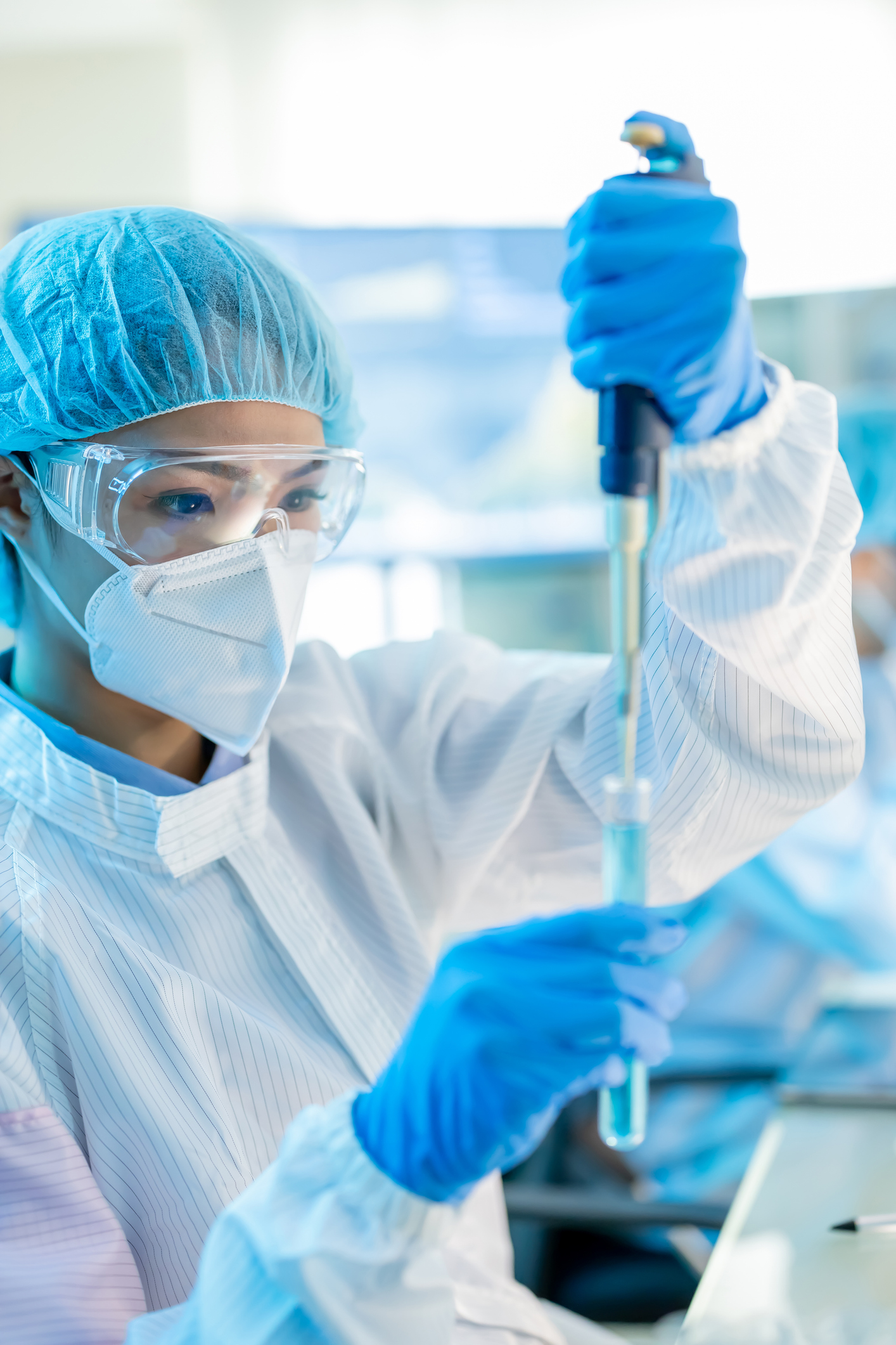asian biotechnology female scientist take test tube to conduct experiments in the laboratory