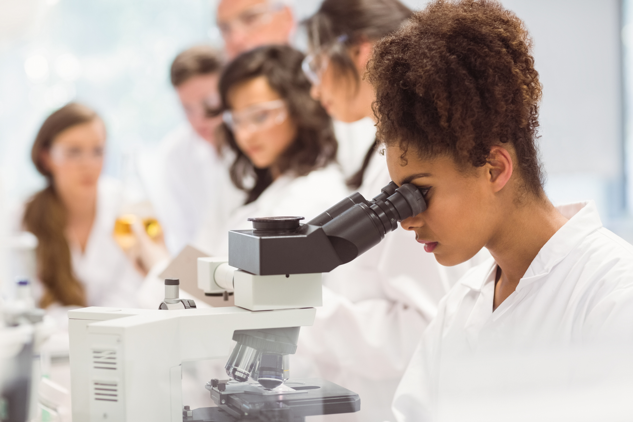 Science student looking through microscope in the lab at the university
