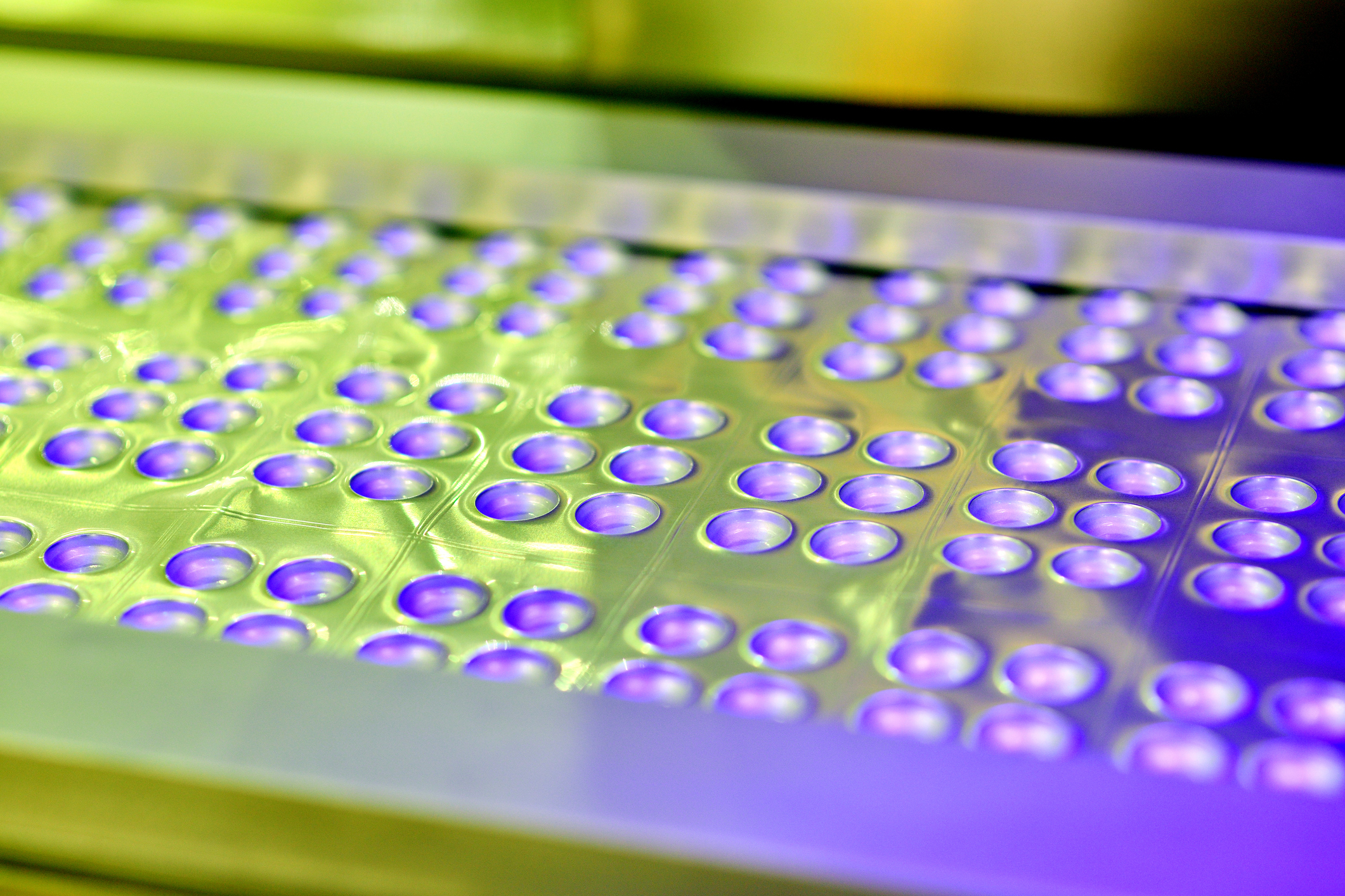 Close-up of foil-material medicine pill package production line.