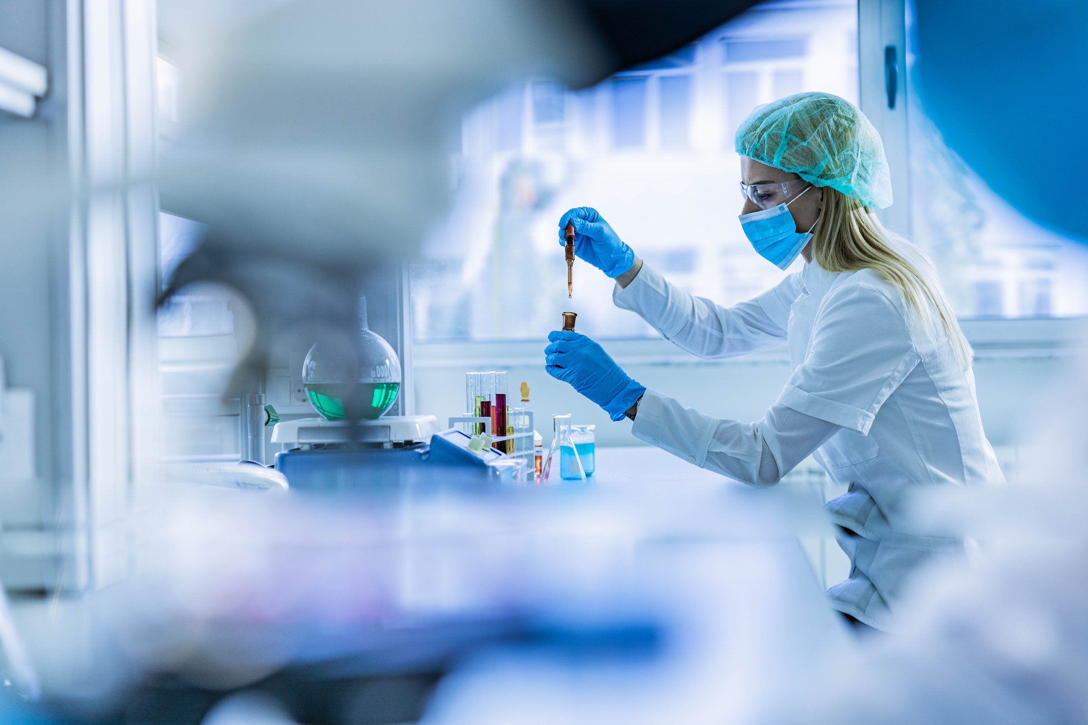 Young female chemist working with poisonous liquid in a laboratory.